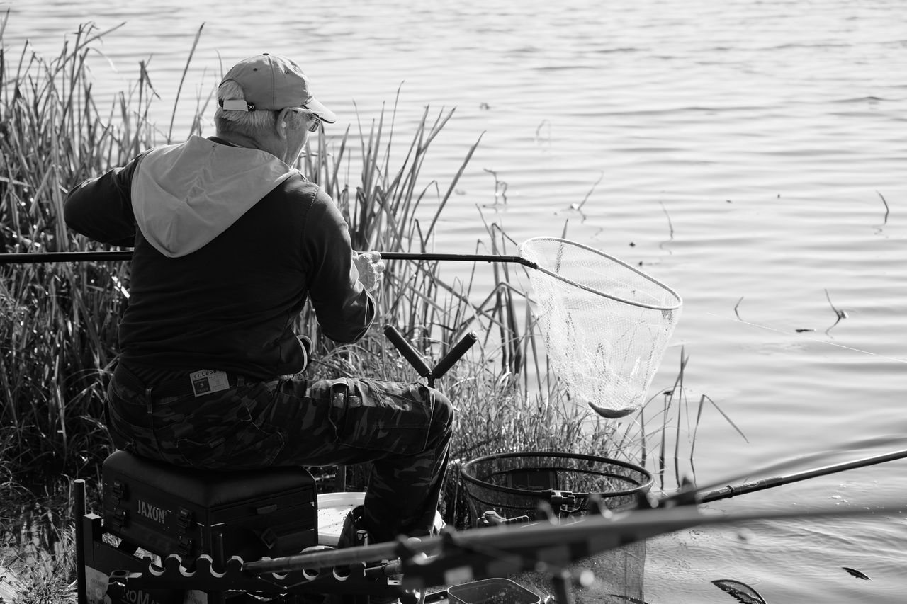 Angler beside a quiet lake at first light